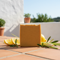 Lemon Grove tallow soap bar on terracotta surface with lemon slices and lemongrass